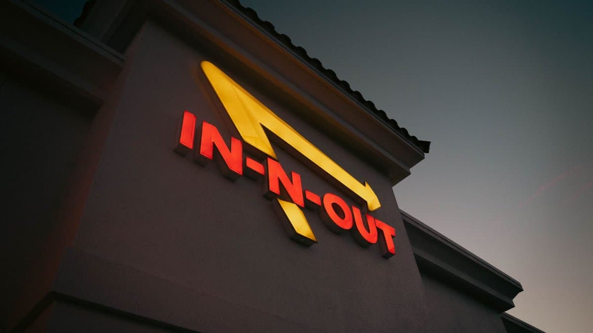 Dramatic shot of In-N-Out Burger sign with vibrant colors at dusk, capturing iconic branding.