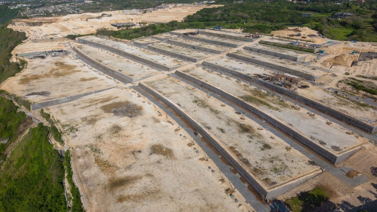 Expansive aerial view of a large construction site in Bali, Indonesia under a cloudy sky.