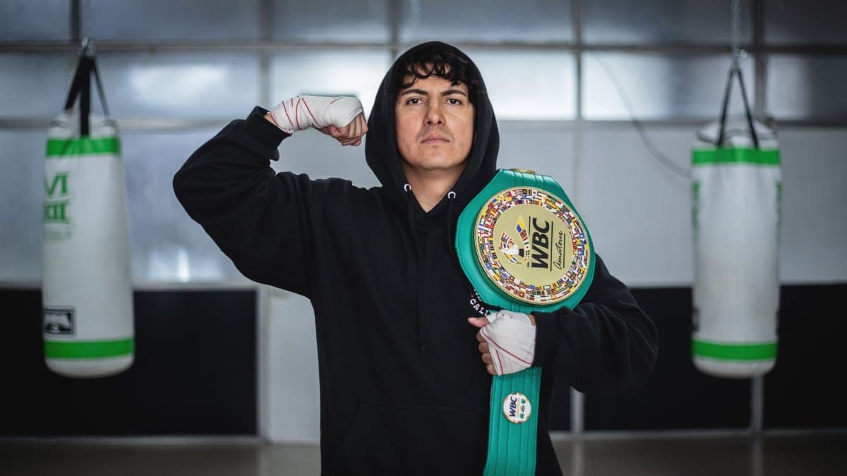Champion boxer posing with WBC belt in Buenos Aires training gym.