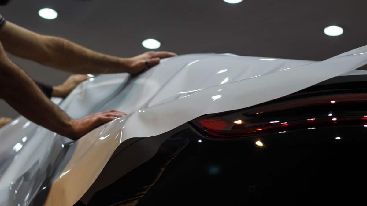 Professional car wrapping in progress, showcasing sleek modern vehicle enhancement.