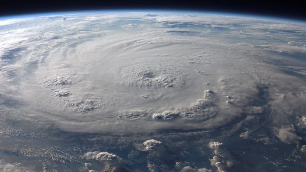 A stunning aerial view of Earth with a massive swirling hurricane, highlighting meteorological beauty.