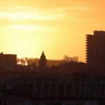 Silhouette of San Francisco cityscape with Ghirardelli sign at sunset.