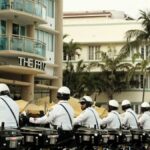 Line of motorcycle police officers in Miami Beach, capturing urban architecture and tropical vibe.