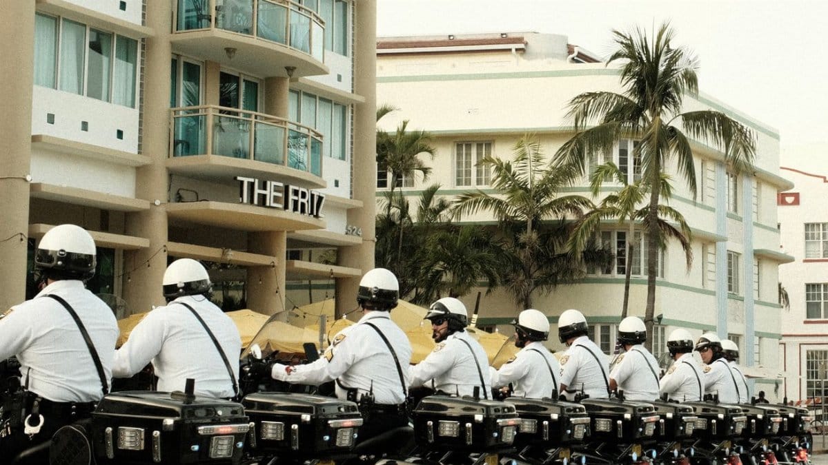 Line of motorcycle police officers in Miami Beach, capturing urban architecture and tropical vibe.
