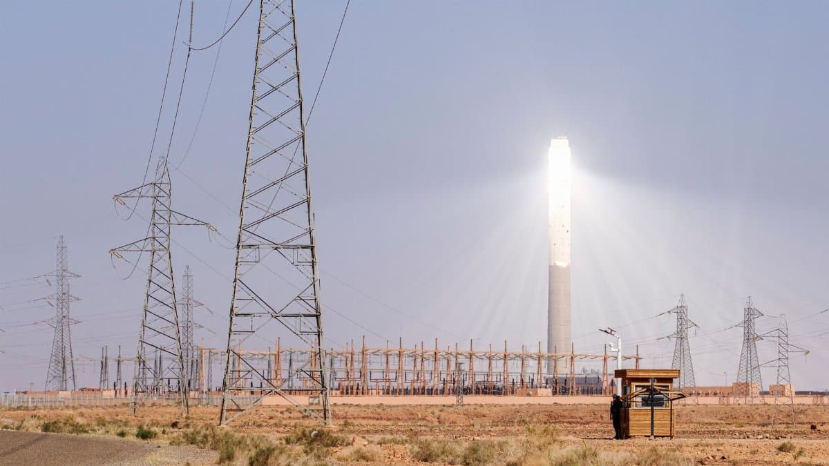 Solar power station with transmission towers in Morocco's desert. Renewable energy infrastructure.