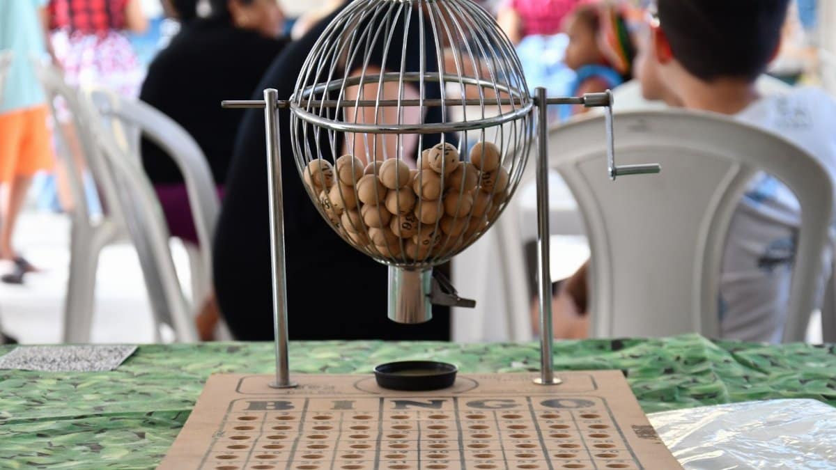 Close-up of a bingo cage with numbered balls and board, ready for play.