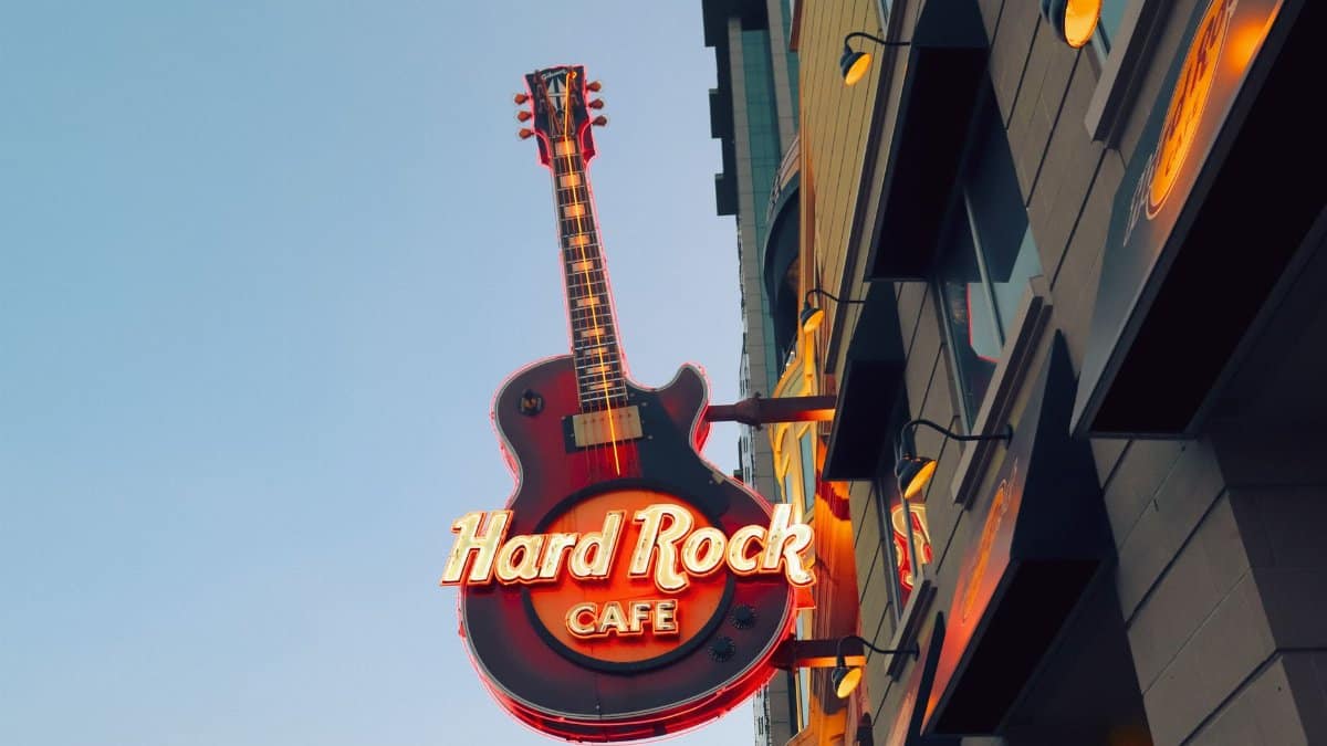 Vibrant neon guitar sign of Hard Rock Cafe in Ontario against clear sky.