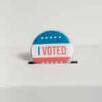 Close-up of an I Voted badge on a ballot box, symbolizing voting in the USA elections.