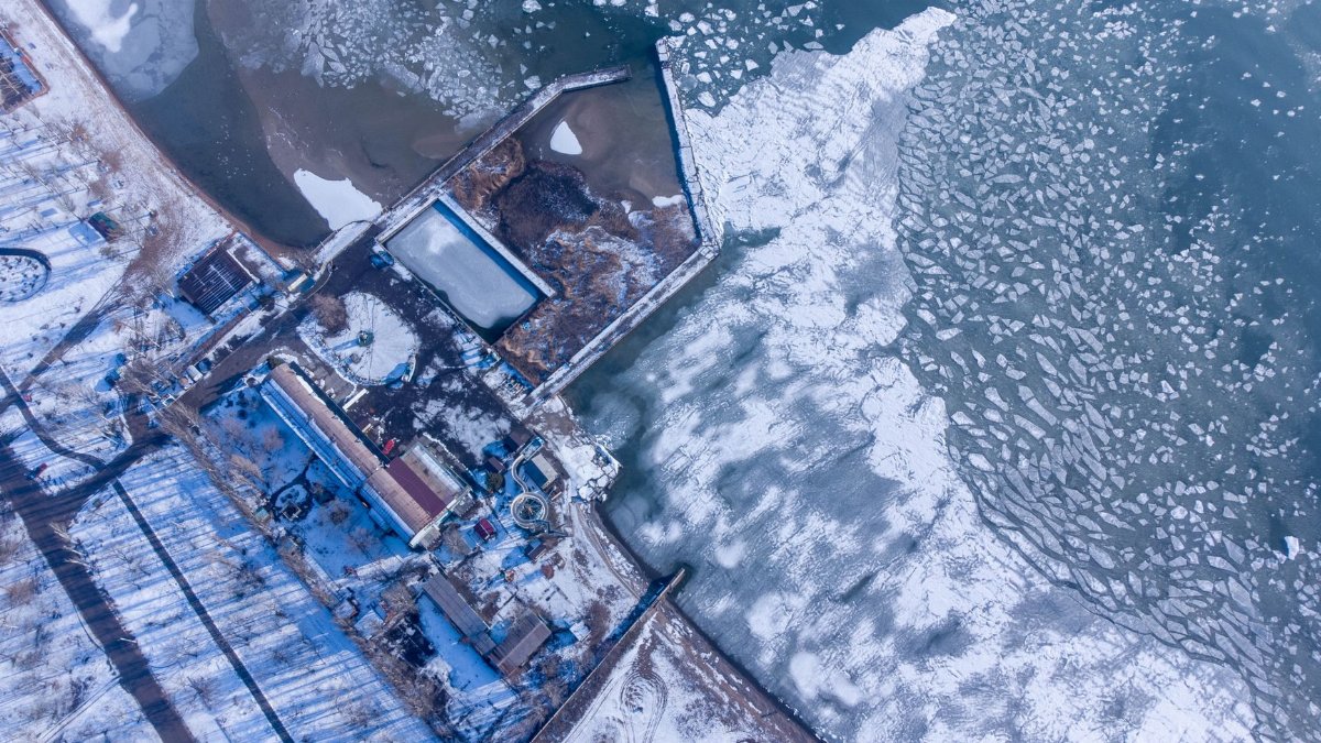 A stunning aerial view of the frozen coastline in Mariupol, Ukraine, showcasing icy patterns on the sea.