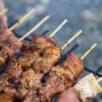 Close-up of delicious grilled meat skewers cooking on a barbecue grill, perfect for outdoor gatherings.