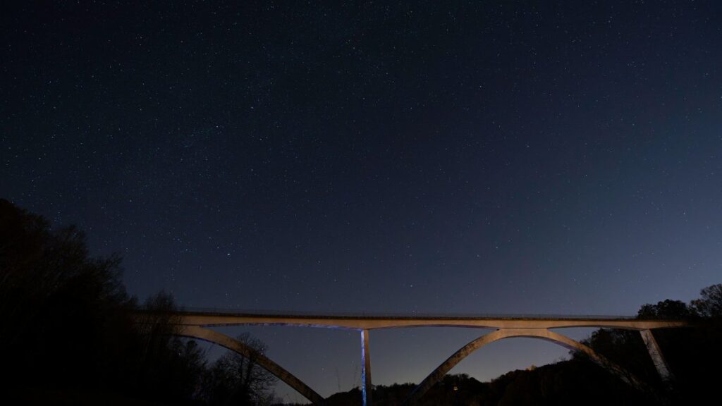 A stunning view of the Natchez Trace Bridge under a star-filled night sky in Nashville, Tennessee.