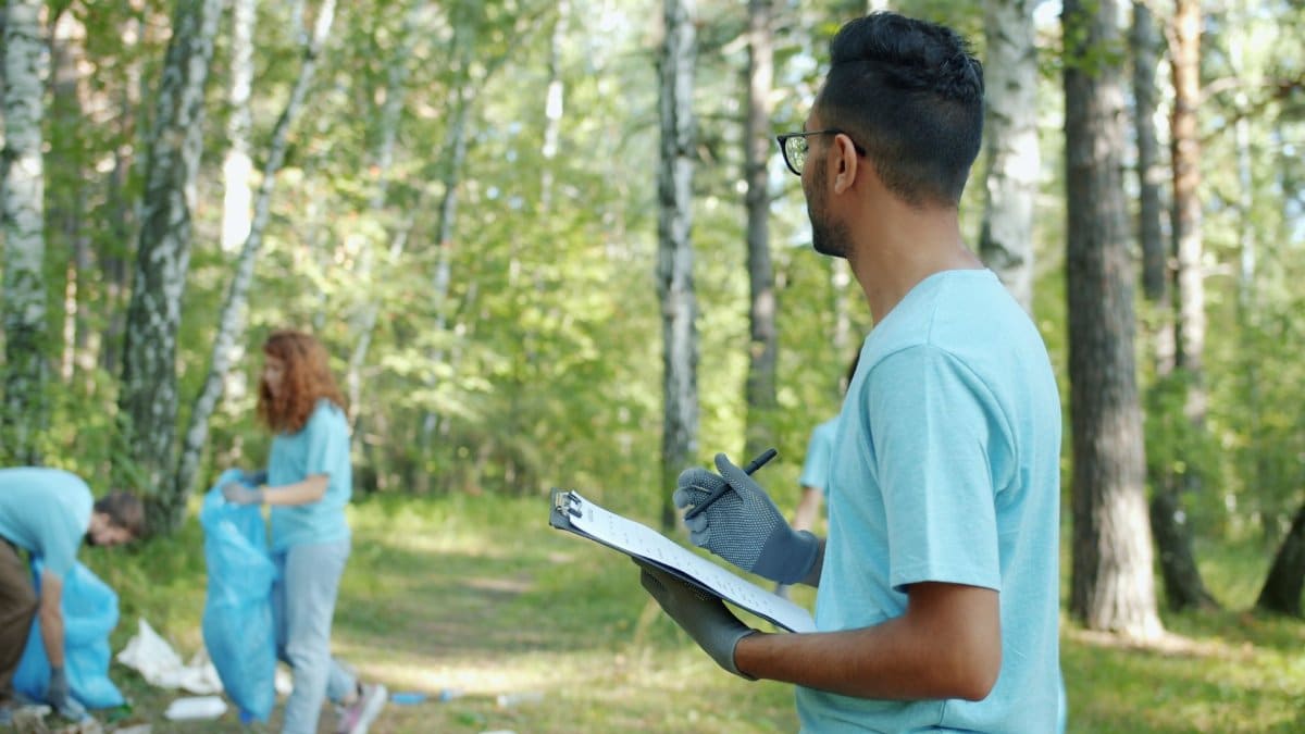 Volunteers collect litter in a forest, showcasing teamwork and environmental care.