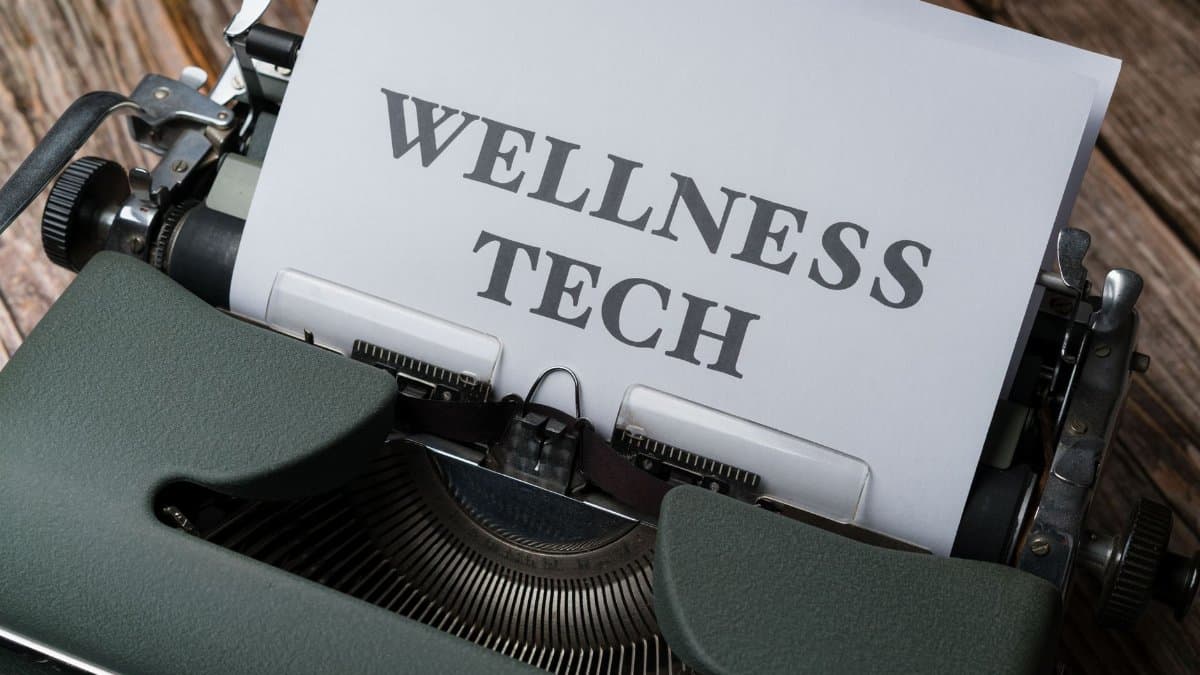 Close-up of a typewriter with paper displaying 'WELLNESS TECH'.