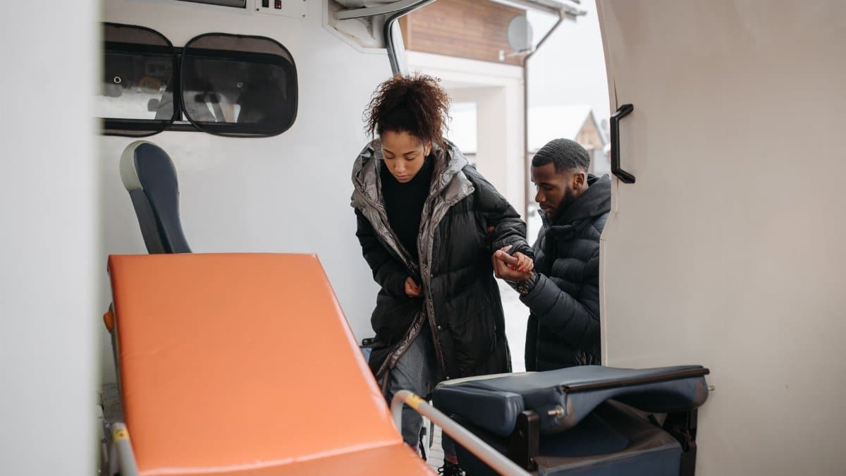 A compassionate scene of helping a person into an ambulance, highlighting emergency care.