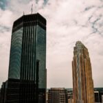 Aerial view of Minneapolis skyscrapers with a partly cloudy sky overhead.