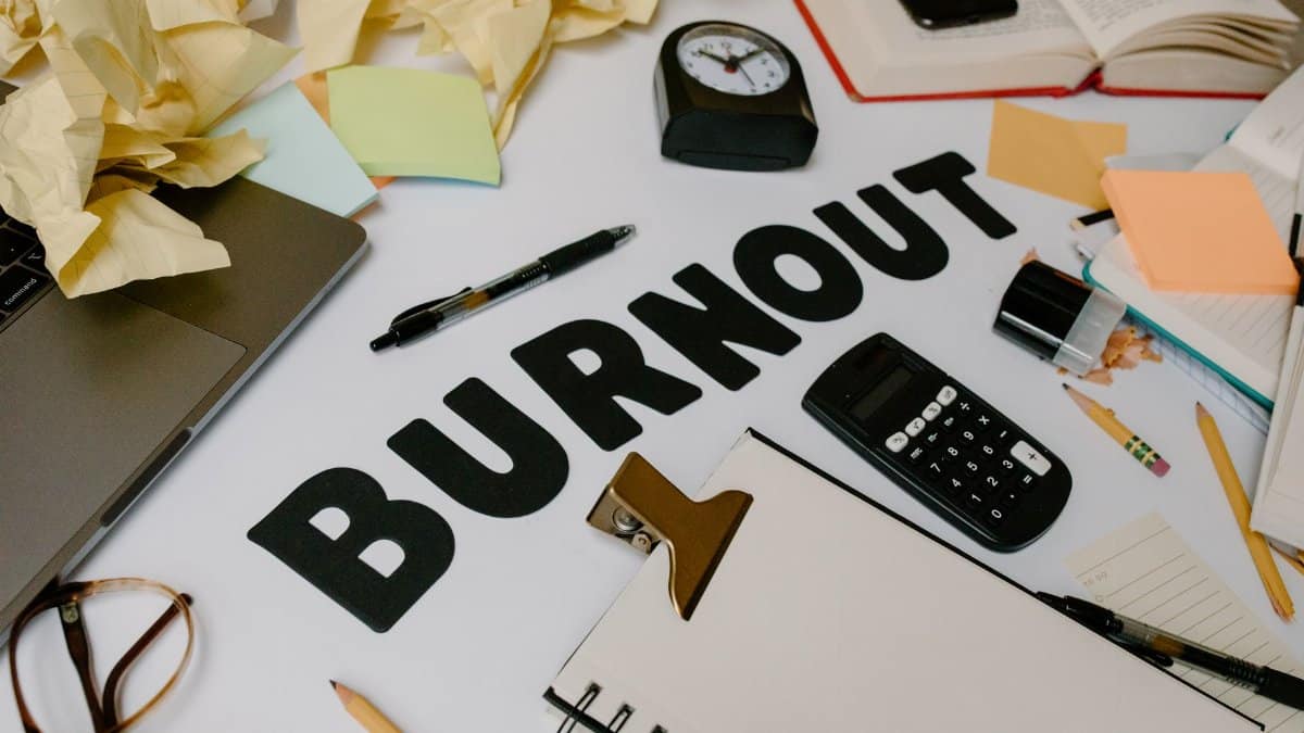 A cluttered office desk symbolizing burnout and stress, with crumpled papers and office supplies.
