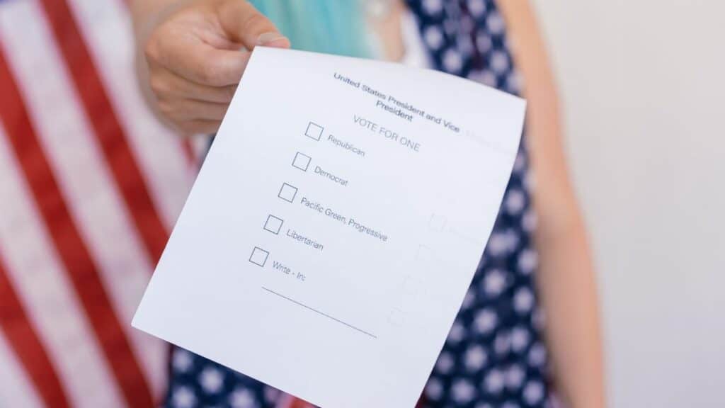 Close-up photo of a hand holding a US election voting ballot.