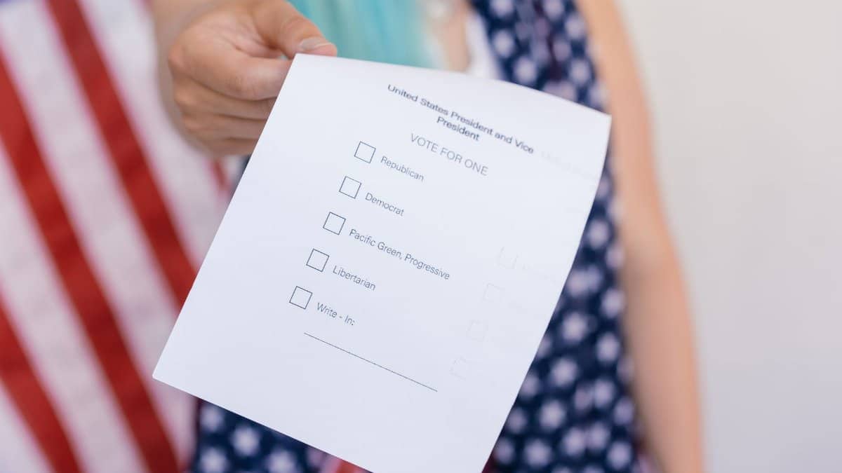 Close-up photo of a hand holding a US election voting ballot.
