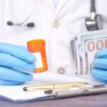 Doctor in gloves holding pill bottle and cash, highlighting medical expenses.