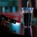 Close-up of cinema tickets and a soda cup on a counter. Ideal for entertainment themes.