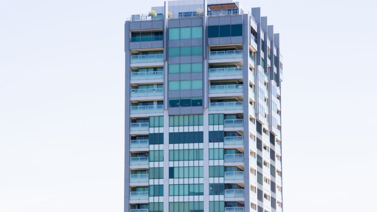 A modern high-rise building with glass windows and balconies in Melbourne, Australia.