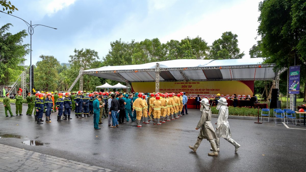 Firefighters in uniform gather for a safety and training event outdoors.
