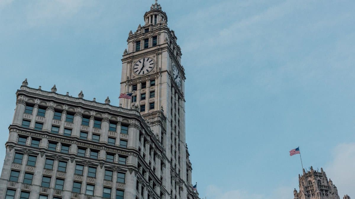 Low-angle shot of the historical Wrigley Building under a clear blue sky in Chicago.
