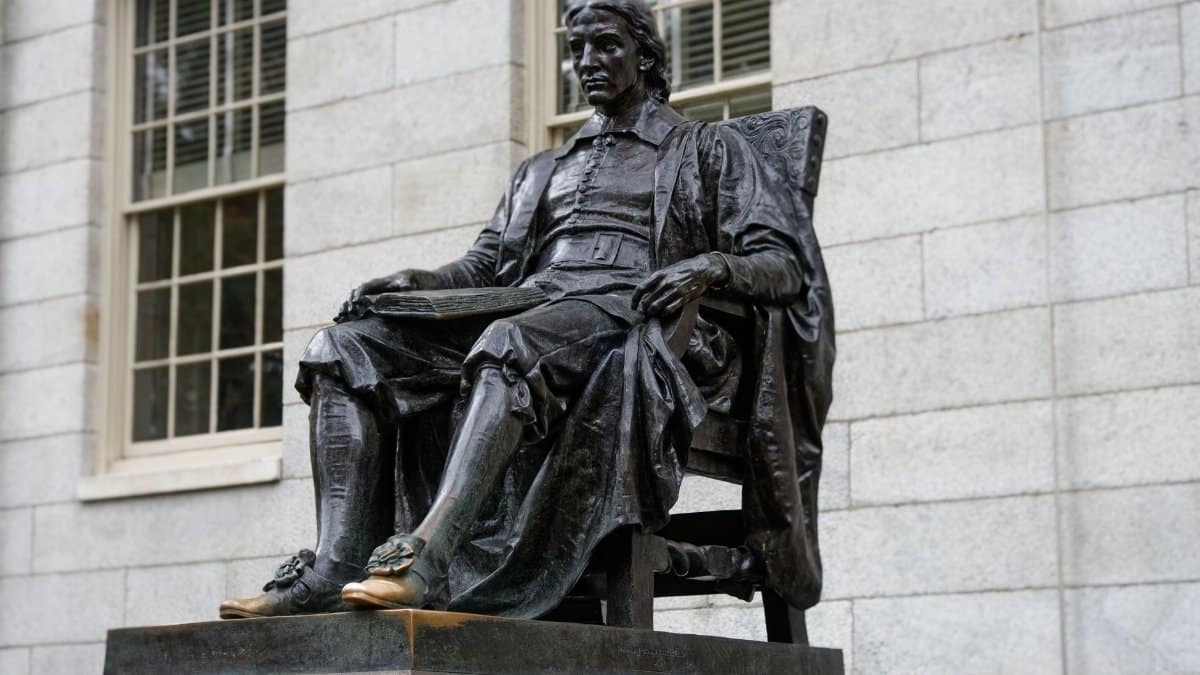 Bronze statue of a historical figure seated, located at a prestigious university.