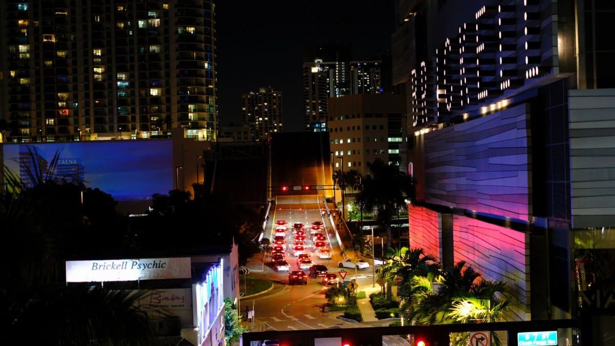 Night view of bustling Brickell with city lights, traffic, and skyscrapers.