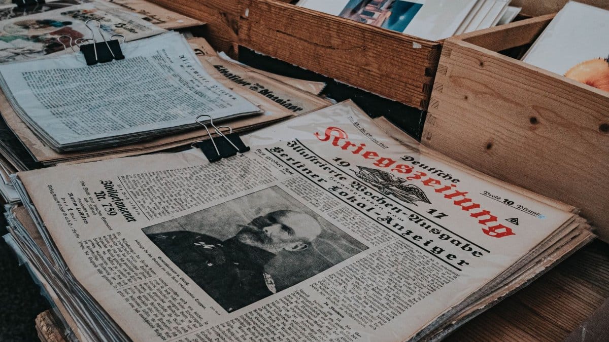 Retro German newspapers featuring historical portraits in wooden boxes, evoking a vintage aesthetic.