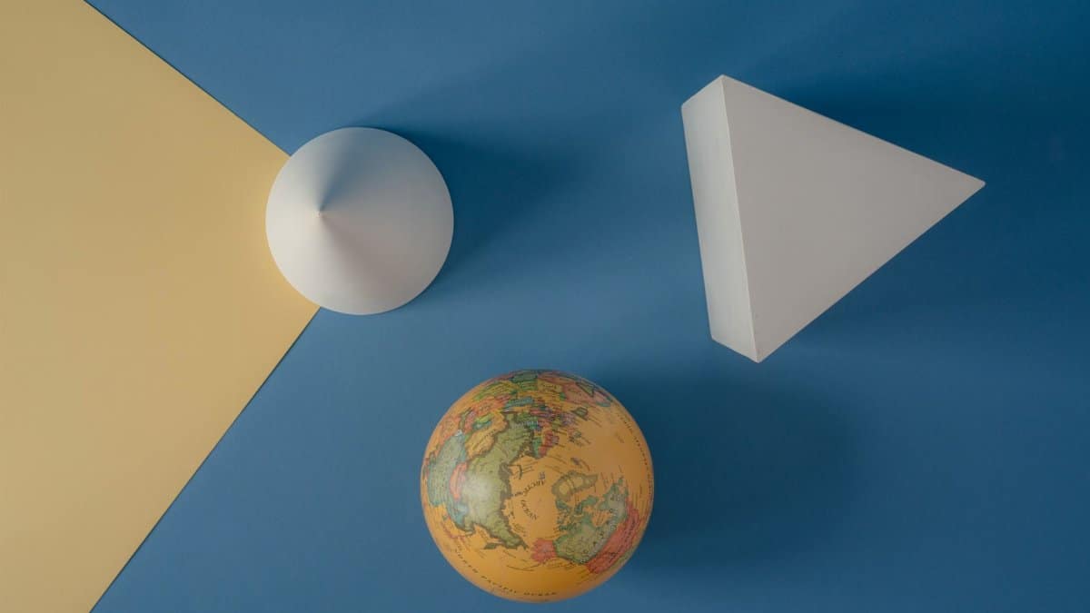 Abstract arrangement of geometric shapes and a globe on a colorful background.