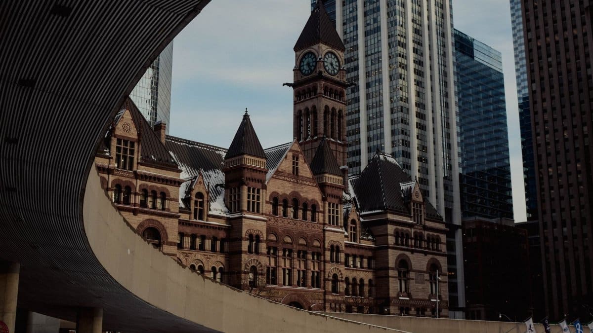 A striking view of Toronto's Old City Hall with surrounding skyscrapers, showcasing architectural contrast.