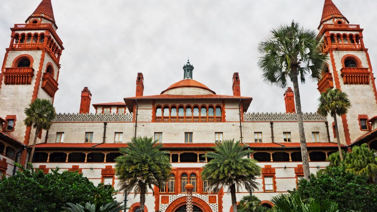 Stunning architectural facade of Flagler College in St. Augustine, Florida with lush palm trees.