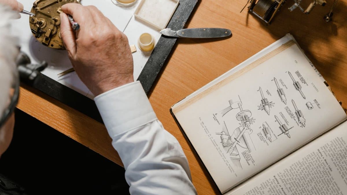 An elderly watchmaker intricately repairing a clock mechanism, guided by a detailed manual.
