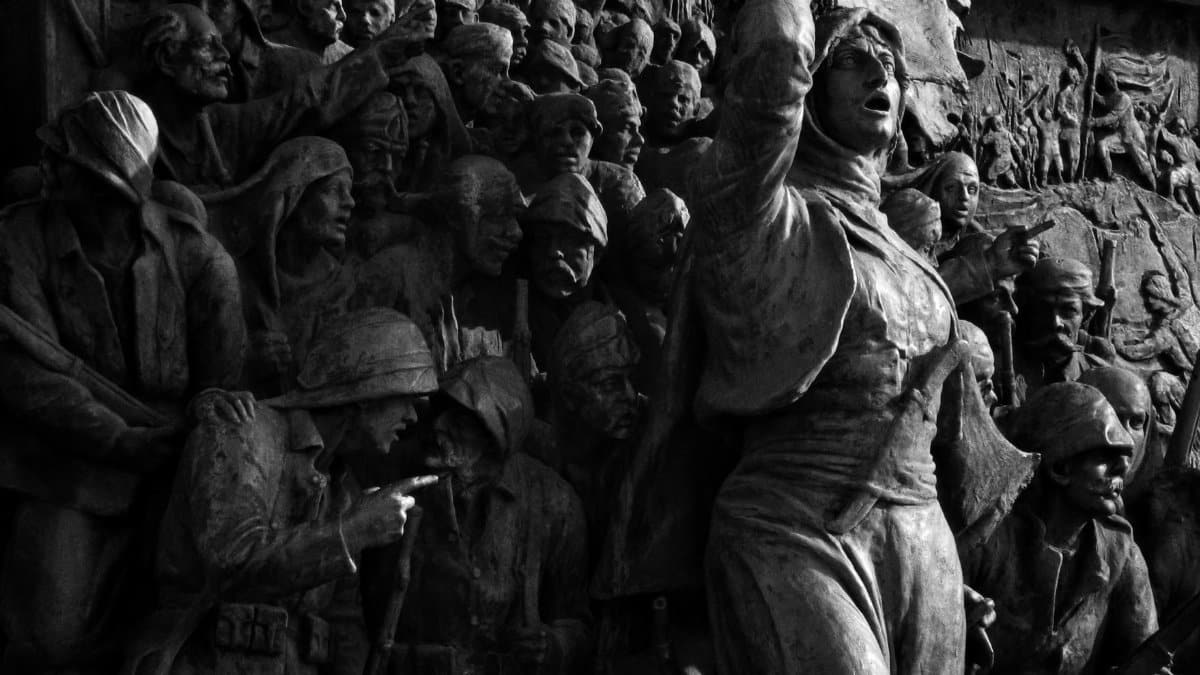 A powerful black and white sculpture depicting a historical battle scene, emphasizing emotion and unity.