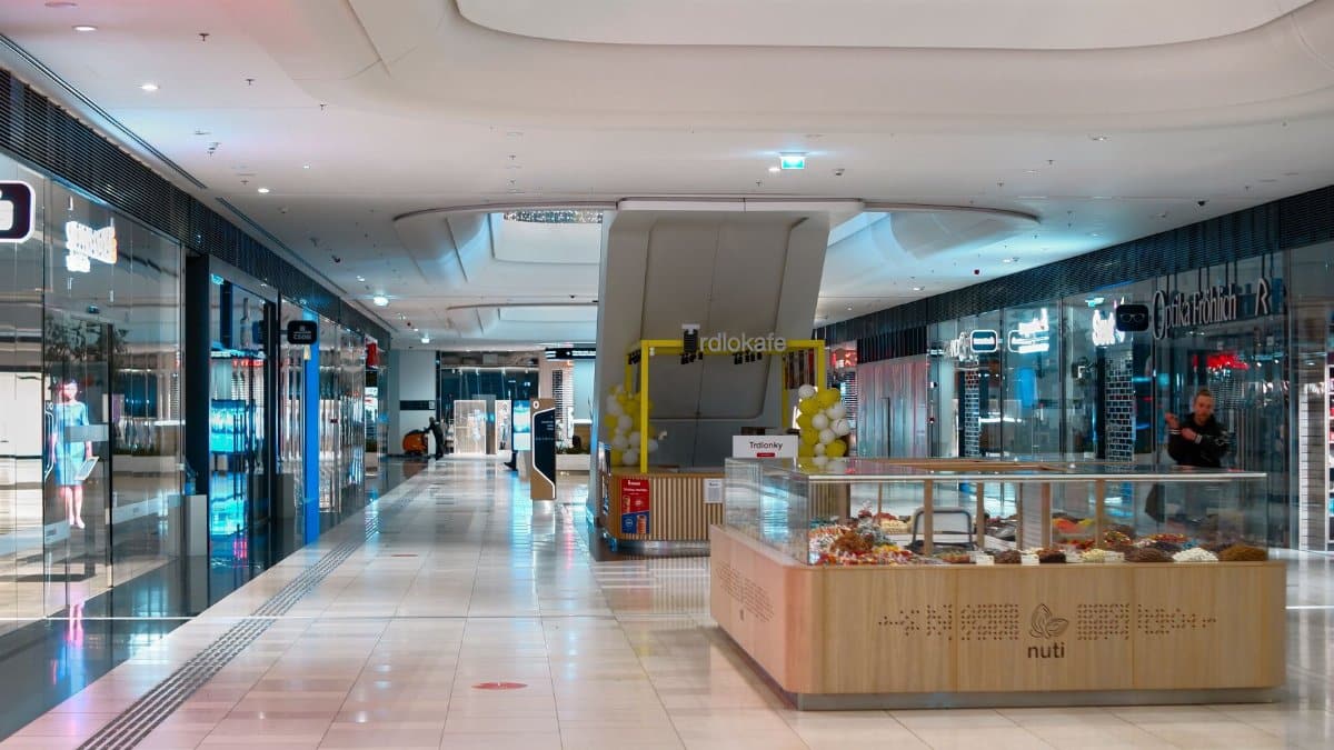 Spacious shopping mall interior in Bratislava with shops, escalators, and vibrant lighting.