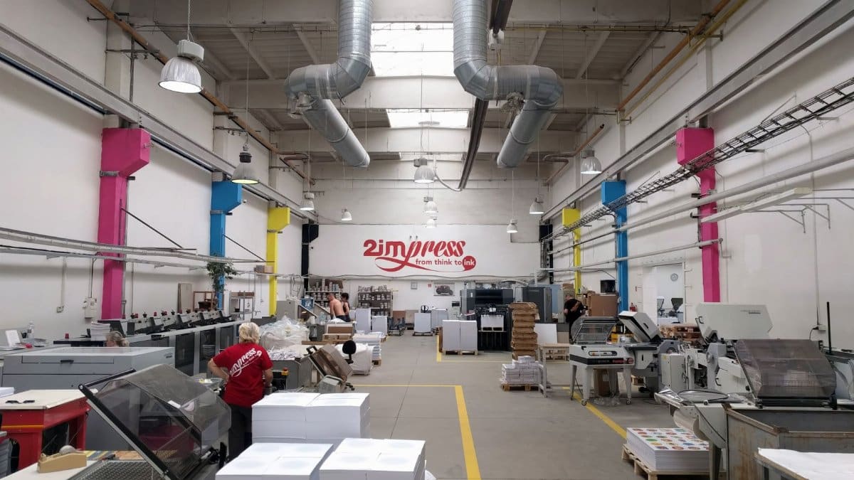 Spacious printing facility with modern machinery and workers engaging in tasks.