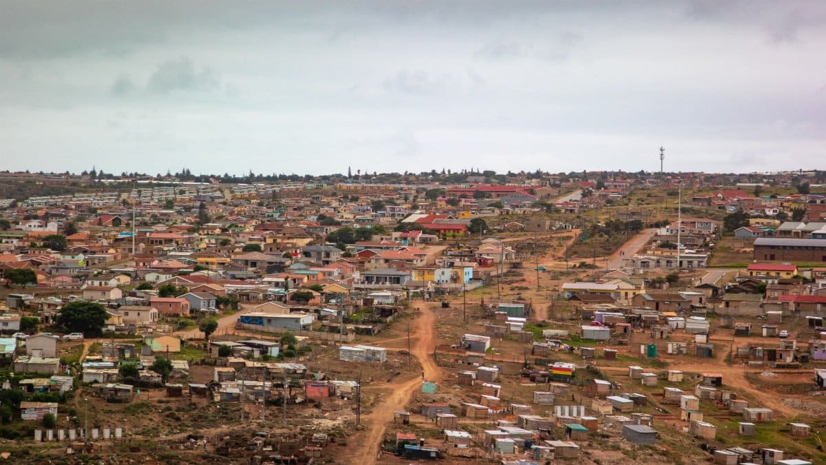 Aerial landscape of a residential area with mixed housing under cloudy skies.