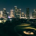 Stunning aerial view of Houston skyscrapers illuminated at night with vibrant city lights.
