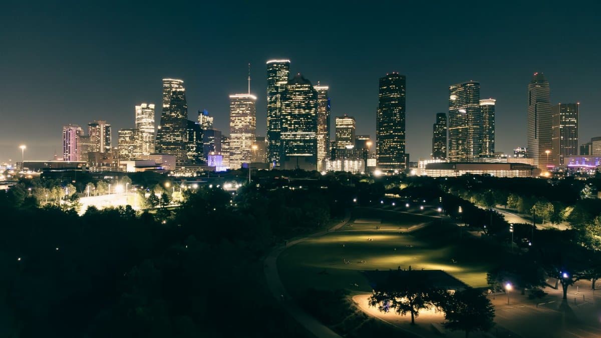Stunning aerial view of Houston skyscrapers illuminated at night with vibrant city lights.