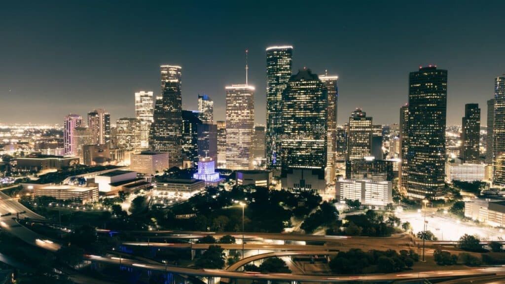 Stunning aerial view of Houston's illuminated skyline featuring skyscrapers and highways at night.