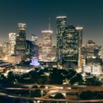 Stunning aerial view of Houston's illuminated skyline featuring skyscrapers and highways at night.