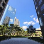 Modern skyscrapers framing the vibrant Houston skyline under a bright blue sky.