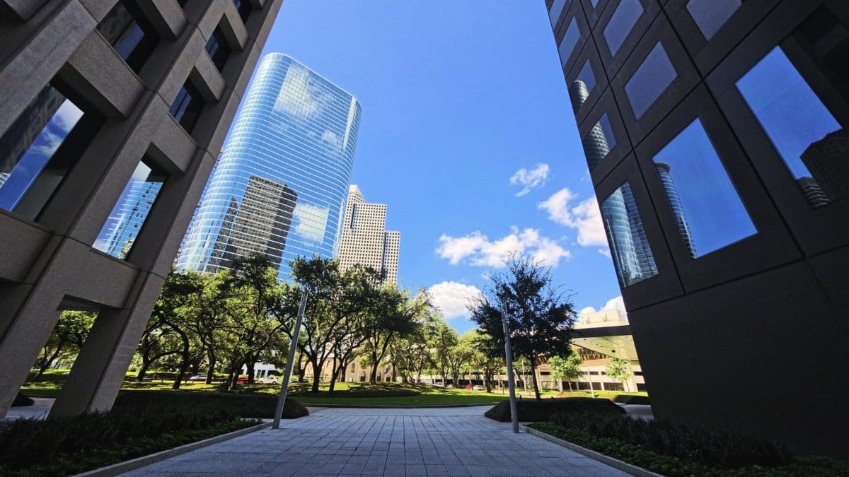 Modern skyscrapers framing the vibrant Houston skyline under a bright blue sky.