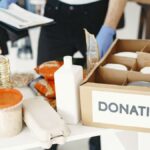 Close-up of donation box with various food items and supplies for community support.