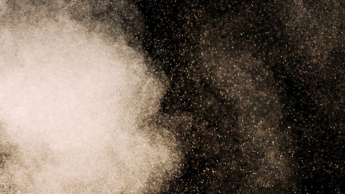 Abstract image of dust particles floating against a dark background, perfect for creative designs
