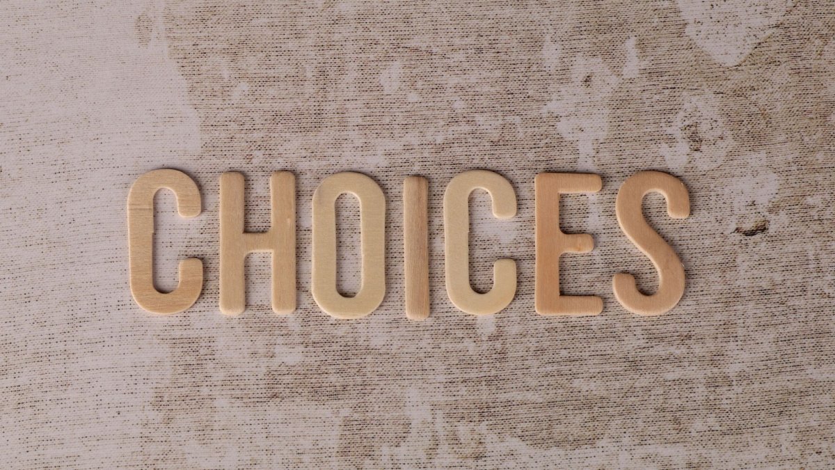 Wooden letters spelling 'choices' on a textured surface, symbolizing decision-making.