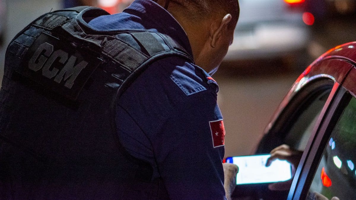 A GCM officer checks documents during night traffic control in Londrina, Brazil.