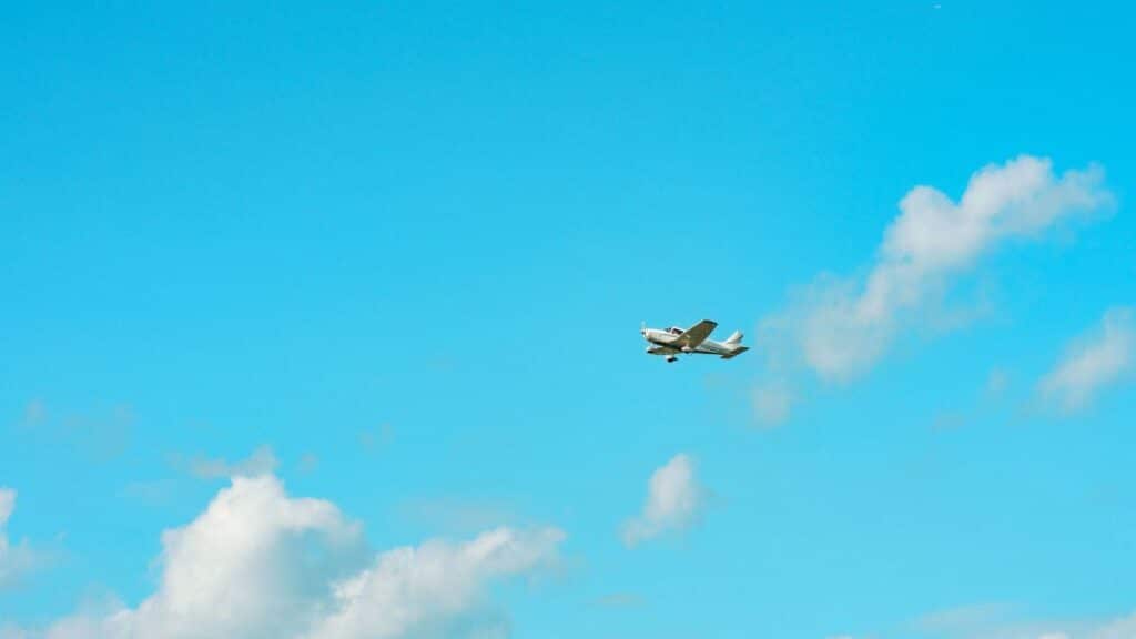 A small plane soaring through a clear blue sky over Stratford, Ontario, Canada.