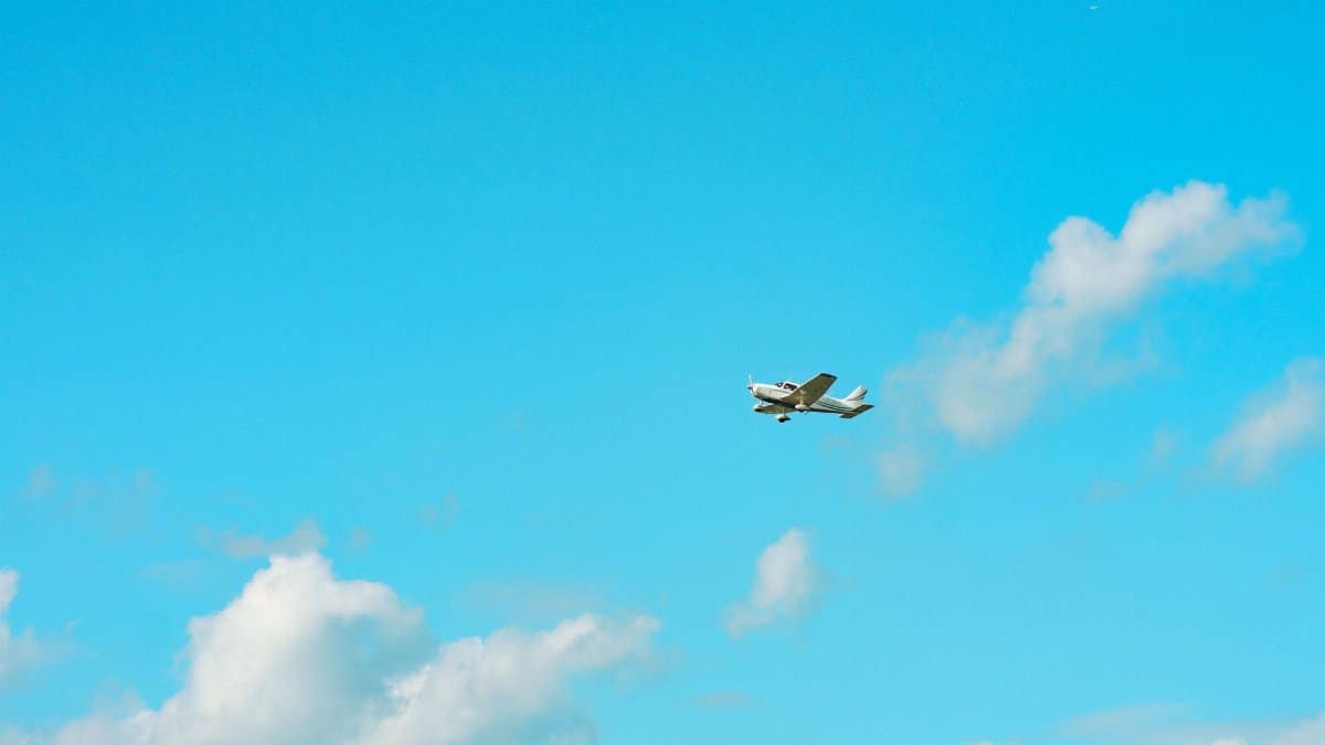 A small plane soaring through a clear blue sky over Stratford, Ontario, Canada.
